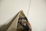 Antique Kerman fragment pillow edge; lustrous cochineal red and blue pile meeting light backing.