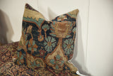 Antique Kerman rug fragment pillow, highlighting deep cochineal red and abrashed blue floral motifs.