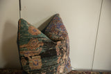 Distressed Anatolian rug fragment pillow, featuring faded teal, brown, and lavender colors.