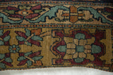 Detailed weave of an antique Kerman rug fragment showing floral and turtle-like cartouche motifs.