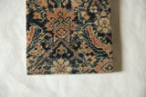 Detailed weave of an antique Fereghan rug fragment showing its partial Herati design.