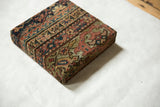 Angled view of the decorative cork board showing the wrapped antique Fereghan rug fragment.