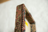 Woven texture and construction detail of an antique Fereghan rug fragment wrapped edge.