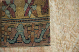 Detailed texture of a late 18th-century Kerman rug fragment with muted floral designs.