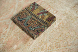 A corner view of the decorative cork board, showing its depth and antique Kerman rug pile.
