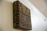 Side profile of the cork board showing its 2-inch depth wrapped in antique Kerman rug art.