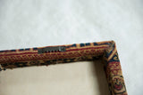 Back corner of the Kerman rug art showing the mounted sawtooth wall hanger.
