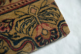 Detailed corner view of the decorative cork board's antique Art Nouveau Kerman rug covering.