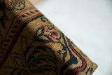 The tight, woven texture of an antique Kerman rug fragment with Art Nouveau design.