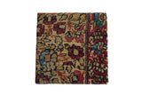 Decorative cork board using an antique Kerman rug fragment with red and blue floral petals.