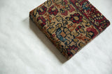 Angled view of the decorative cork board showcasing the antique rug fragment's texture and thick profile.