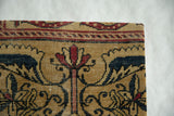 Corner detail of an antique Kerman rug fragment showing its woven texture and serpent border.