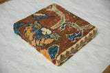 Angled corner view of a decorative cork board wrapped in a textured antique Ziegler Mahal rug fragment.