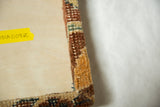 The reverse corner of the cork board showing the antique rug fragment neatly wrapped.