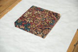 Edge view of Kerman rug fragment art, with cochineal red and sapphire blue floral pattern.