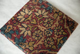 Thousand flower motif on antique Kerman fragment in cochineal red and sapphire blue hues.