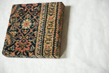 Angled view of the Fereghan rug art, showing the Herati pattern and the wrapped vine border.