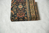 Side profile of the decorative cork board highlighting the texture of the antique Fereghan rug.