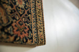 Side view of the cork board showing its thick profile and antique germinating vine border.
