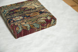 Corner detail of a decorative cork board showing the antique Kerman textile's silk-like wool pile.