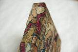 Angled view of the thick wool pile and edge profile of the antique rug fragment art.