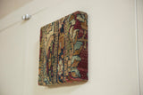 Side profile of the antique rug fragment art, highlighting its depth and thick construction.