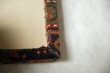 Detailed view of the mitered corner and hand-knotted texture on the antique rug frame.