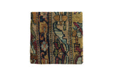 Decorative cork board art featuring an antique Kerman rug fragment with floral motifs in ochre, blue, and rust.