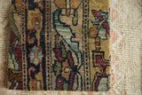 Antique Kerman rug fragment with a dense, lustrous wool pile and intricate floral design.