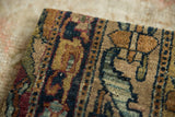 The rich texture and high-gloss wool pile of the antique Kerman rug fragment.