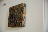 Side profile of the decorative cork board showing its thick, antique rug-wrapped edges.