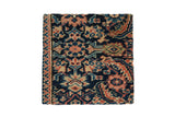 Antique Fereghan rug fragment art on a cork board with floral motifs in navy blue, red, and ivory.