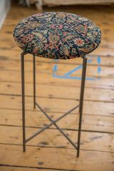Reclaimed antique rug fragment side table with a navy patterned top and slim metal frame.