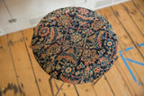 Overhead view of the cushioned tabletop made from an antique Persian Fereghan rug fragment.