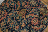 Close-up of the side table's cushioned top showing the antique Fereghan rug's texture in navy and rust.