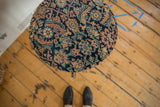 Overhead view of the side table's top, upholstered with an antique Persian rug fragment in navy and rust.
