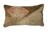 Textured vintage Oushak rug fragment lumbar pillow with faded rose and warm neutral tones, 26 by 15 inches.