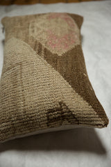 Textured vintage Oushak rug fragment pillow side with natural linen backing.