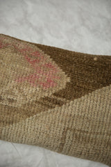 Textured pile close-up of vintage Oushak rug pillow, showing faded rose and brown tones.