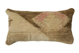 Unique vintage Oushak rug fragment lumbar pillow with textured beige, brown, and pink abstract design.