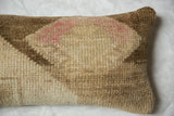 Distressed hand-knotted texture of a vintage Oushak pillow in muted beige and pink.