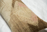 Vintage Oushak fragment pillow's distressed hand-knotted pile, showing beige, brown, and faint pink.