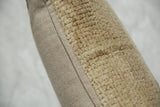 Natural beige Oushak rug fragment pillow, textured knots contrasting with smooth woven backing.