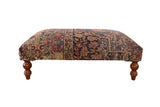 Antique Persian Kerman rug ottoman featuring intricate floral patterns in red, navy blue, and beige.
