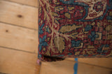 Storied wear and woven texture on the corner of an antique Kerman rug ottoman.