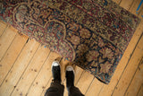 A perspective view showing the scale of the long antique Kerman rug ottoman.