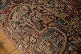 Close-up on the antique Kerman rug fabric, highlighting its hand-knotted texture and visible foundation.