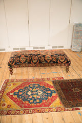 Full view of the long vintage rug ottoman, showcasing its traditional floral upholstery and scale.