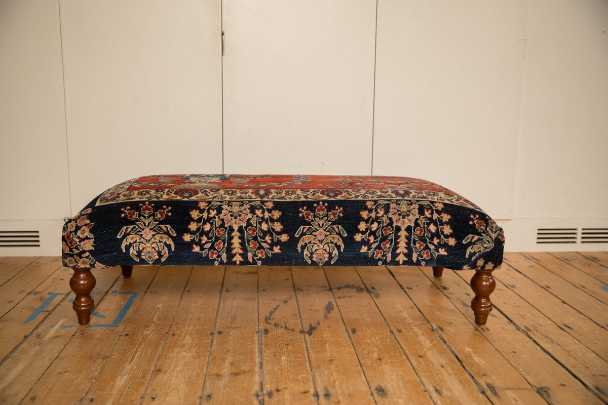 Reclaimed Vintage Persian Rug Ottoman, side view showing navy floral border and curved wooden legs.