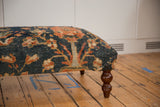 Storied texture and terracotta hues of antique Persian rug fragment, with turned leg.